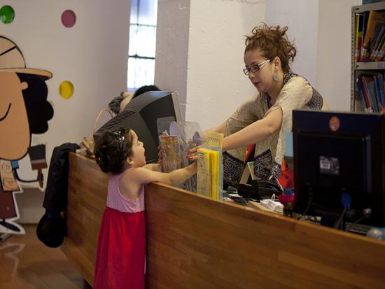 Niña solicitando libro en la Biblioteca de Santiago.