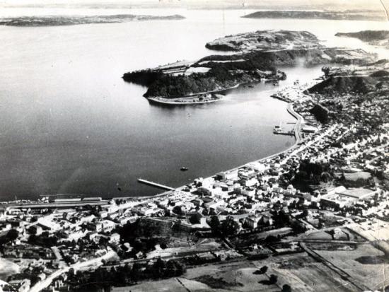 Fotografía aérea del centro de Puerto Montt, el puerto, la isla Tenglo y el canal del mismo nombre. Gentileza Memorias del Siglo XX.